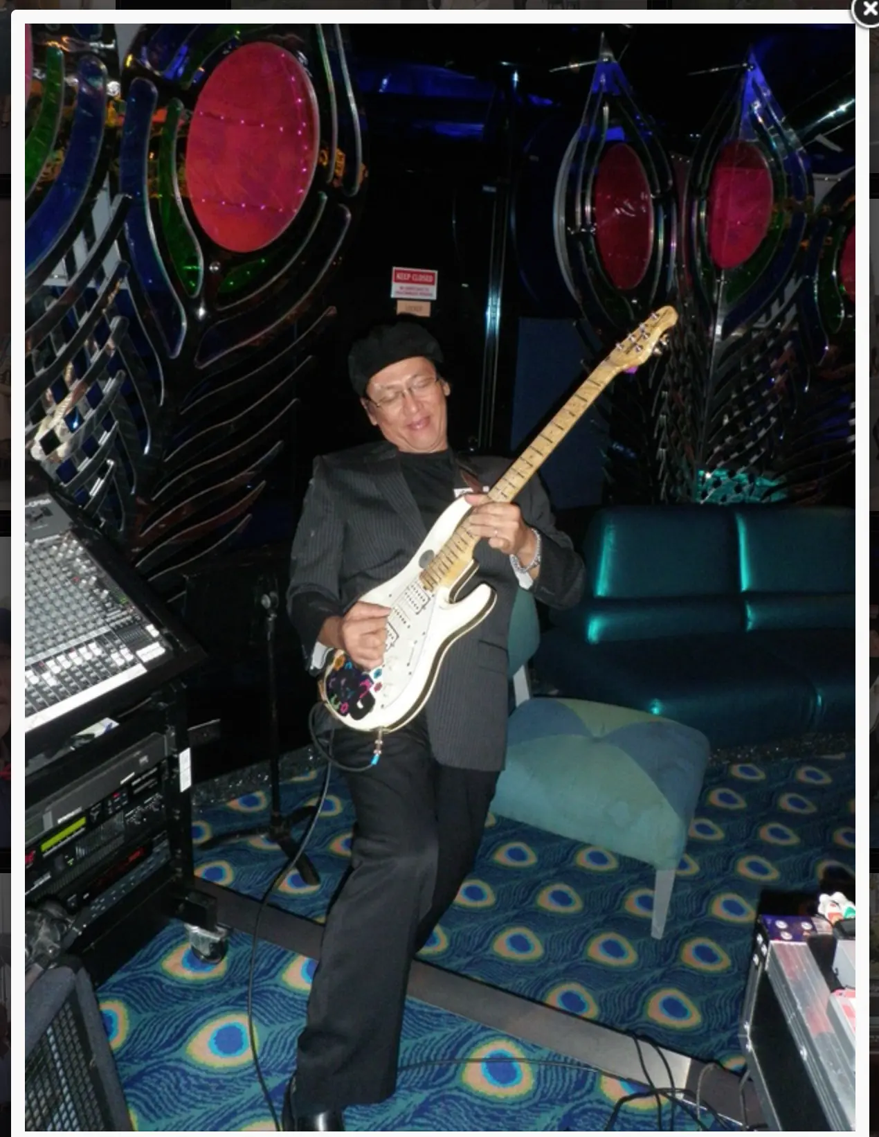 Resty Garcia performing with electric guitar in a cruise ship lounge
